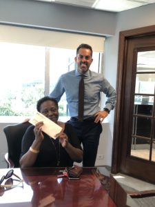 Nassau Personal injury lawyer Frank Bruno with a happy client and their settlement check